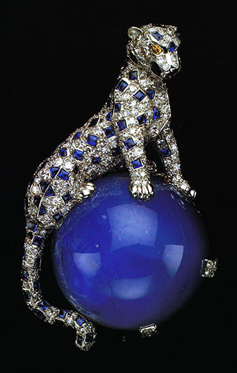 In 1949, the Duchess of Windsor acquired this diamond and sapphire panther pin from Cartier. The panther is crouched in a life like pose on a large perfect round cabochon star sapphire weighing 152.35 carats. This panther pin was one of the Duchess' favorite pieces which she frequently wore. It created an envy among other jewelry collectors and a demand for Cartier to produce more panther pieces. Today, the panther is a Cartier icon. The Duchess of Windsor's animal pieces became her signature.