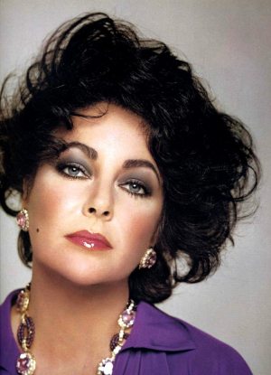 Elizabeth Taylor, age 44, wears her signature color, purple, to match her violet eyes. 1977