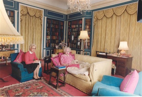 British romance novelist Barbara Cartland dictates stories to her secretary while relaxing with one of her Pekinese pets.